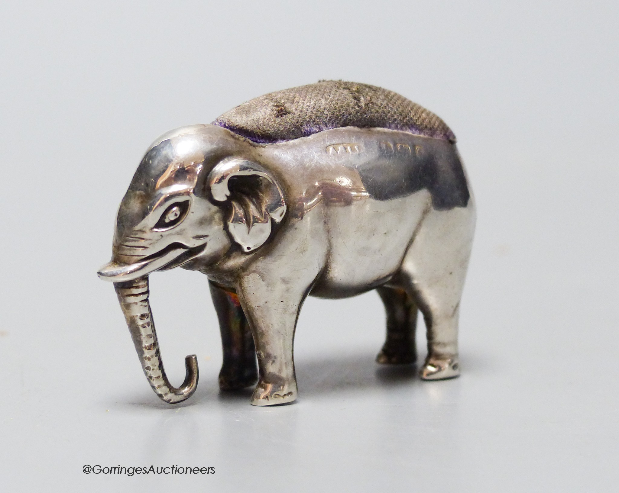 An Edwardian silver elephant pin cushion, Adie & Lovekin, Birmingham, 1906, length 48mm.